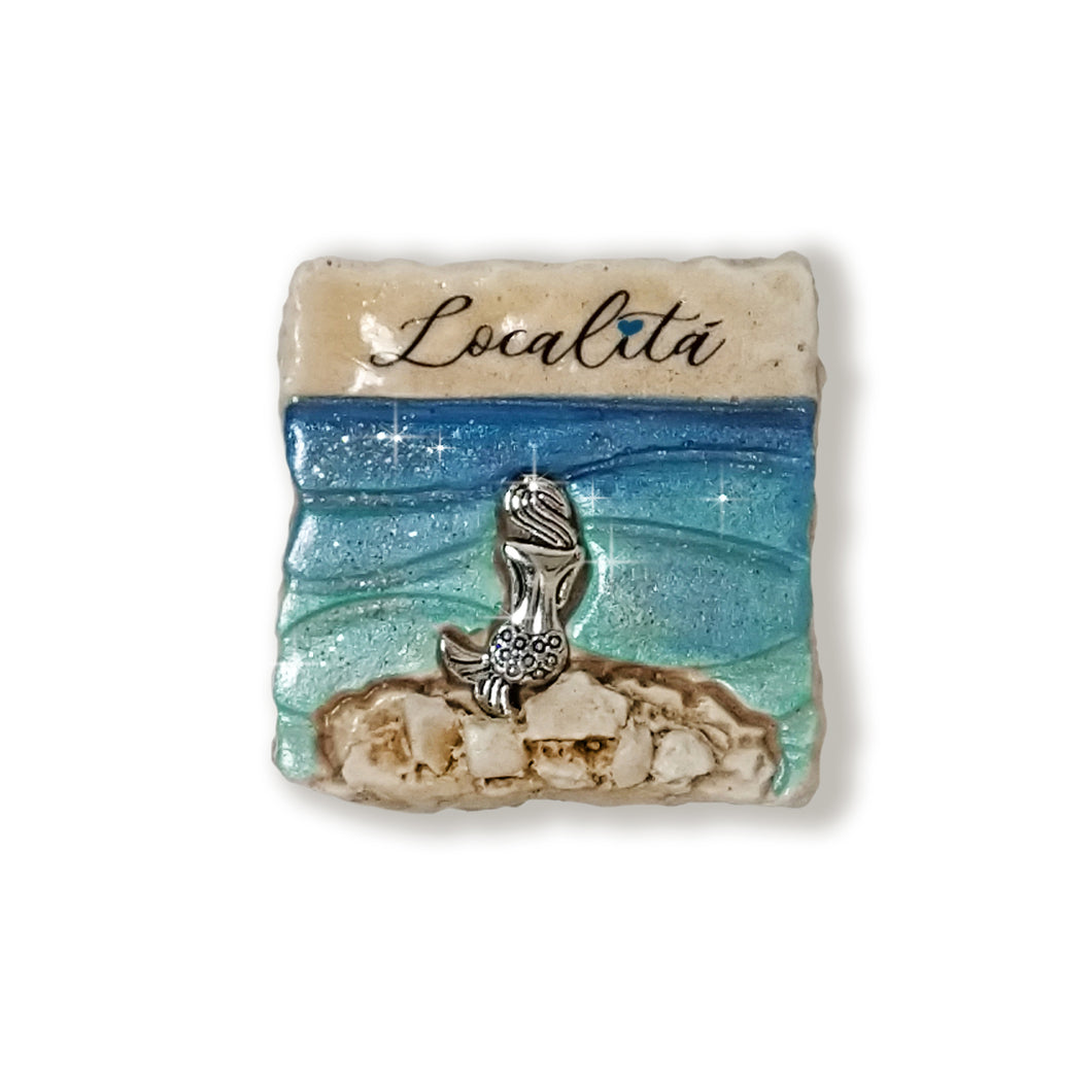Calamita artigianale realizzata in polvere di ceramica atossica e dipinta a mano con colori acrilici.  Personalizzata con il nome della tua località.  Sul retro ha un potente magnete al neodimio e la dicitura 