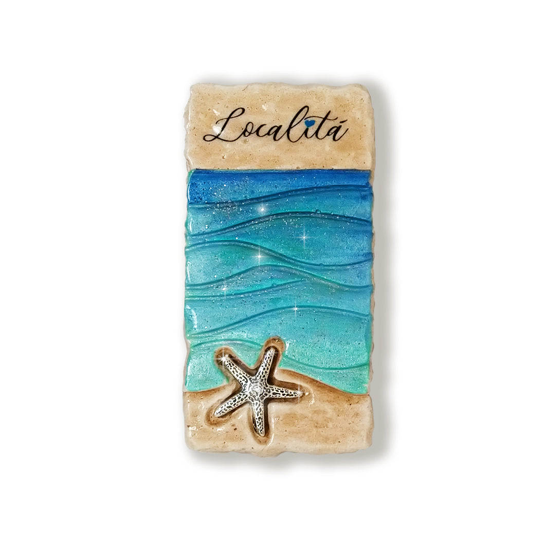 Calamita artigianale realizzata in polvere di ceramica atossica e dipinta a mano con colori acrilici.  Personalizzata con il nome della tua località.  Sul retro ha un potente magnete al neodimio e la dicitura 